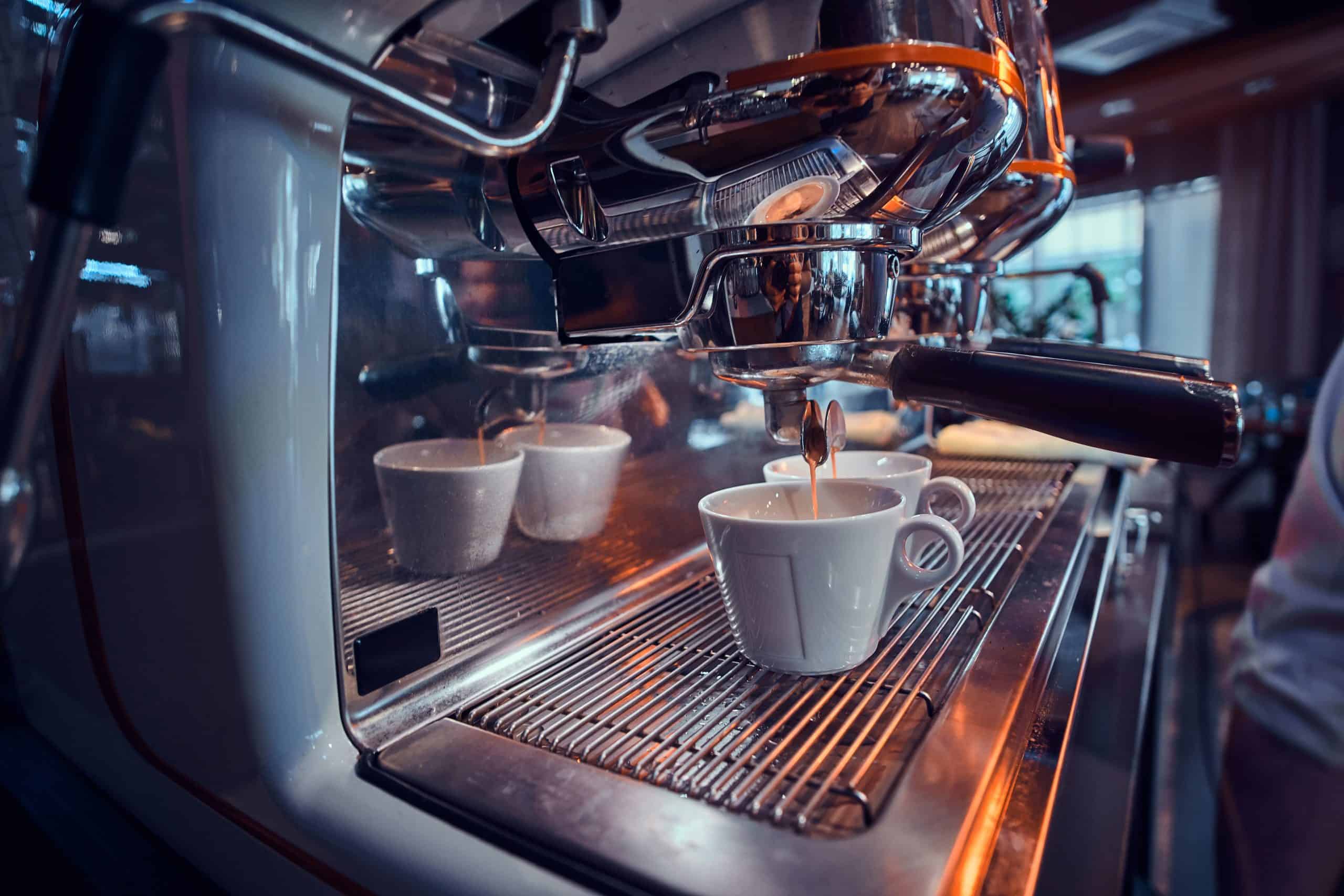Commercial espresso machine for ROI analysis A new shiny commercial espresso machine in a coffee shop, illustrating the renting vs buying decision
